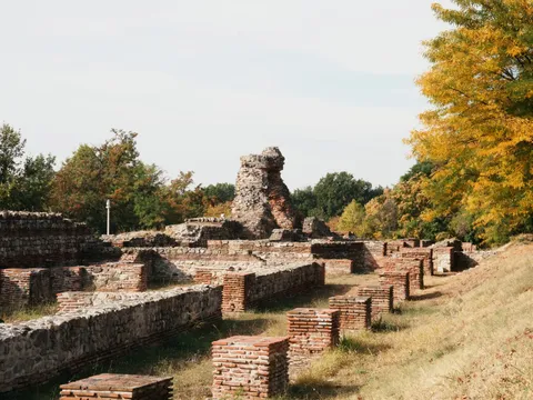 Дългите каменни зидове и редицата тухлени пиластри на базиликата