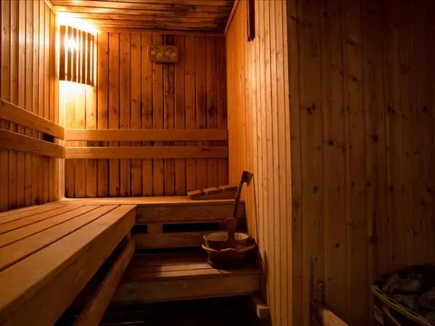 Сауна с дървени пейки, кофичка и черпак