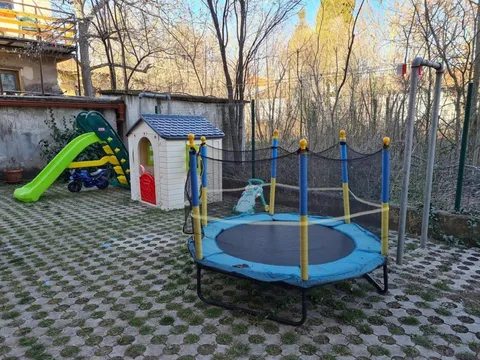 Детски кът в двора с батут, пързалка и малка къщичка