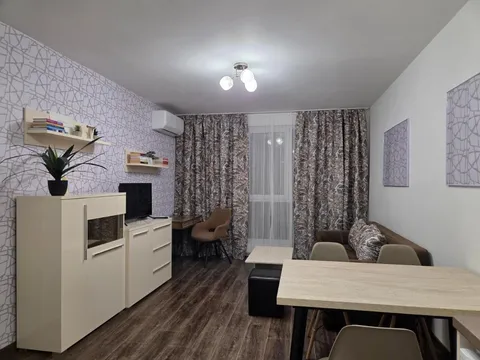 Дневна с маса за хранене, шкаф и телевизор в апартамент „Азария“