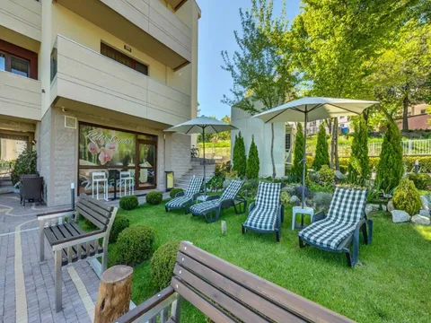 Градина с карирани шезлонги и пейки до входа на Victoriya's House