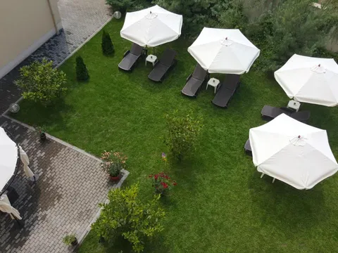 Градината на Хотел Си Комфорт отгоре с бели чадъри и шезлонги