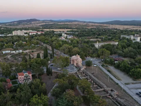 Камилите и крепостната стена отвисоко при розов здрач
