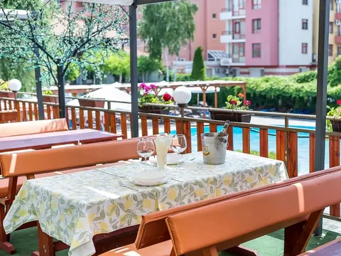 Кът за хранене с маси и пейки под пергола
