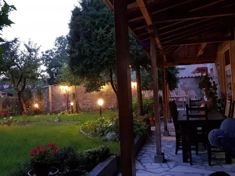 Покрита веранда с маса и столове, осветена вечер