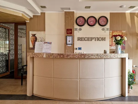 Рецепция с извит плот, три стенни часовника и надпис „Reception“