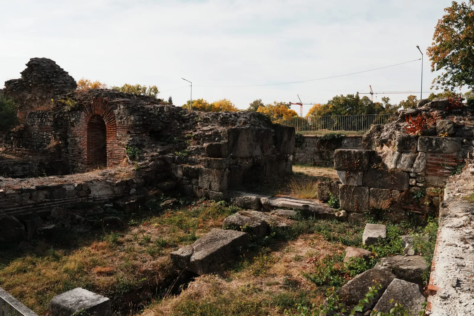 Руините на Източната крепостна порта с тухлена арка и паднали каменни блокове