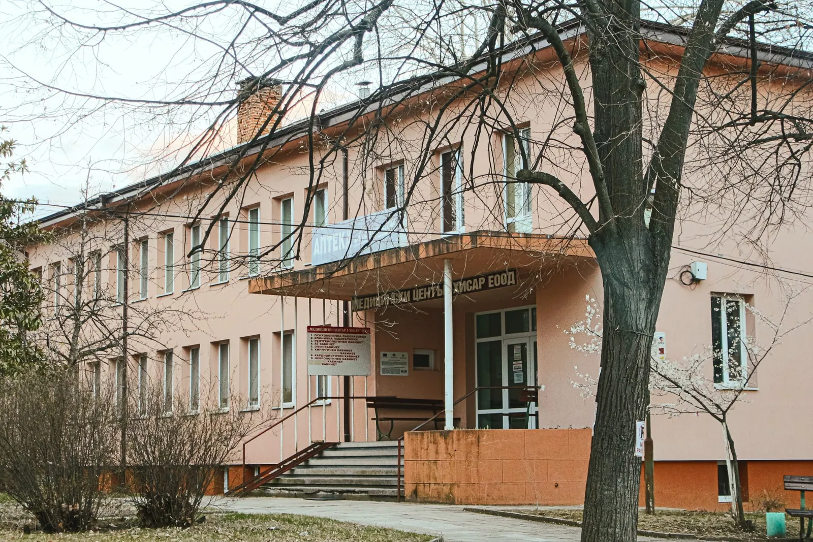 Сградата на Медицински център Хисар с навес над входа и аптека