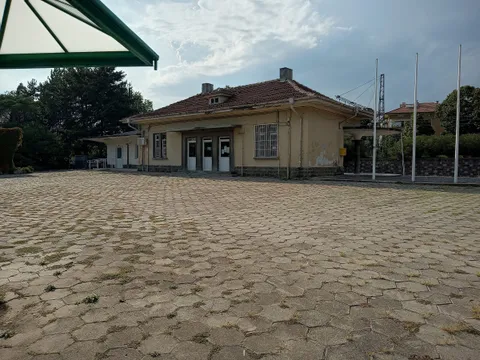 Едноетажната жълта сграда на ЖП гара Хисаря и павираният площад пред нея