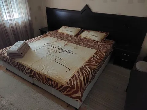 Спалня с голямо двойно легло с тъмна табла