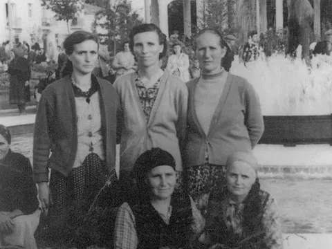 Стара снимка: пет жени, две от тях коленичили, пред фонтана със статуя