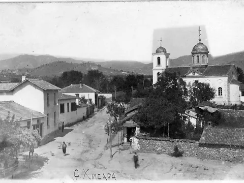 Стара снимка: селска улица и църква с камбанария и купол, планини отзад