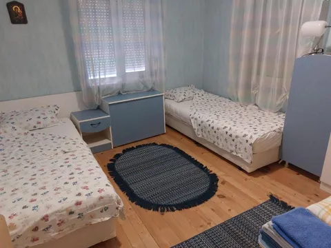 Стая с две единични легла и килим на дървения под