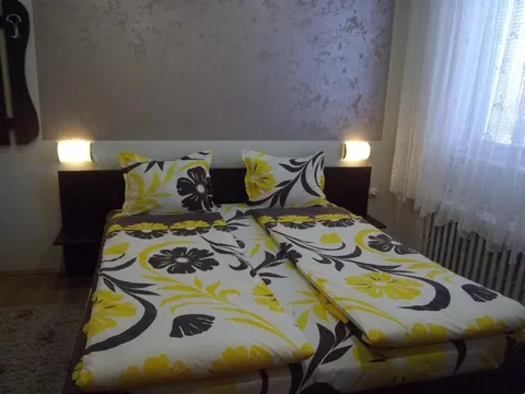 Стая с двойно легло с жълто-черна завивка и нощни лампи