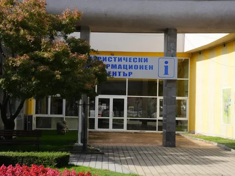 Входът на Туристическия информационен център с остъклена фасада и цветна леха